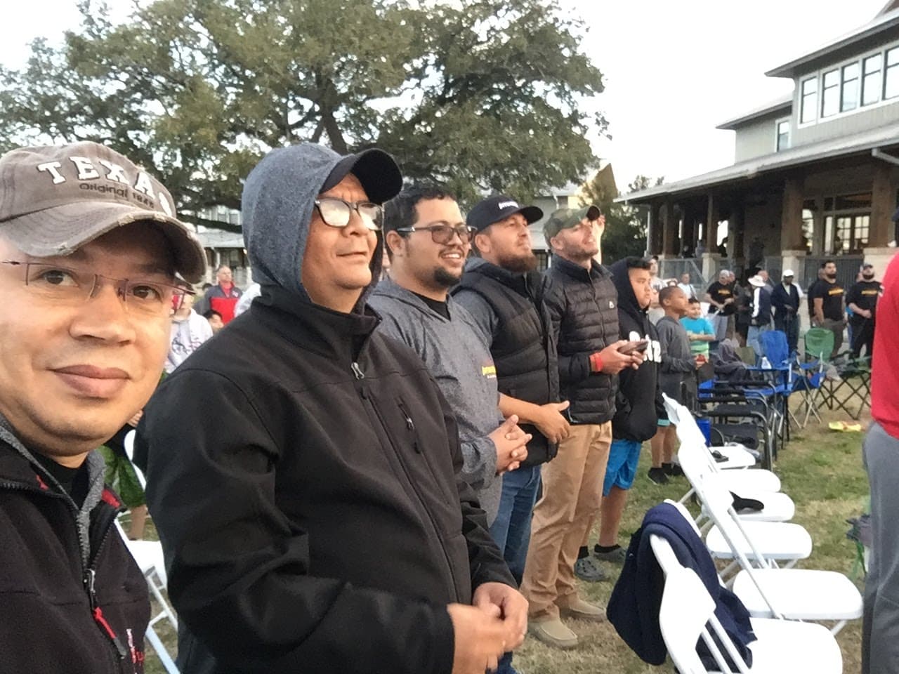 Men gathered at outdoor community event